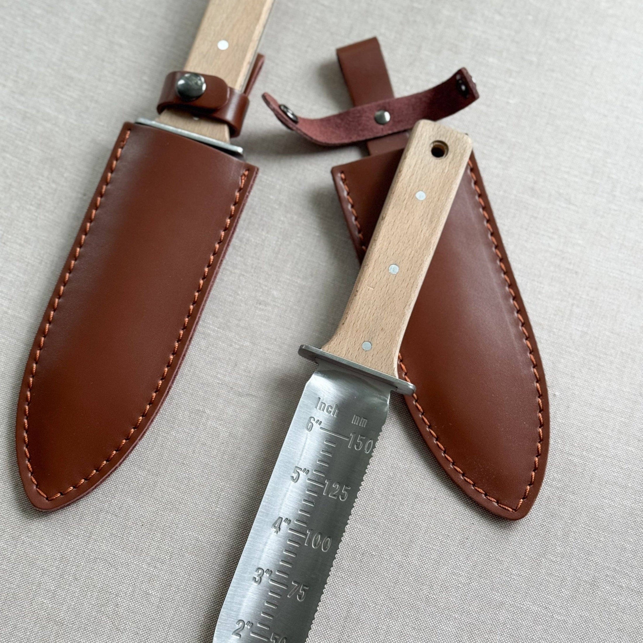 Two hunting knives with leather sheaths on a light gray background